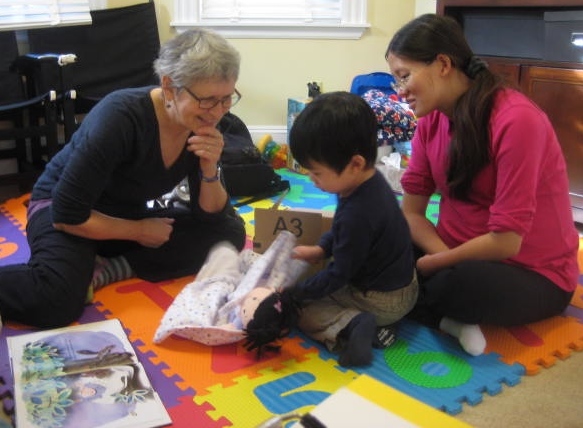 laytime is a wonderful time for rich conversation. Here I am playing new-baby-in-the-family with a toddler and mother during an early literacy home visit. We’re using fun and interesting words like cozy and cuddle.